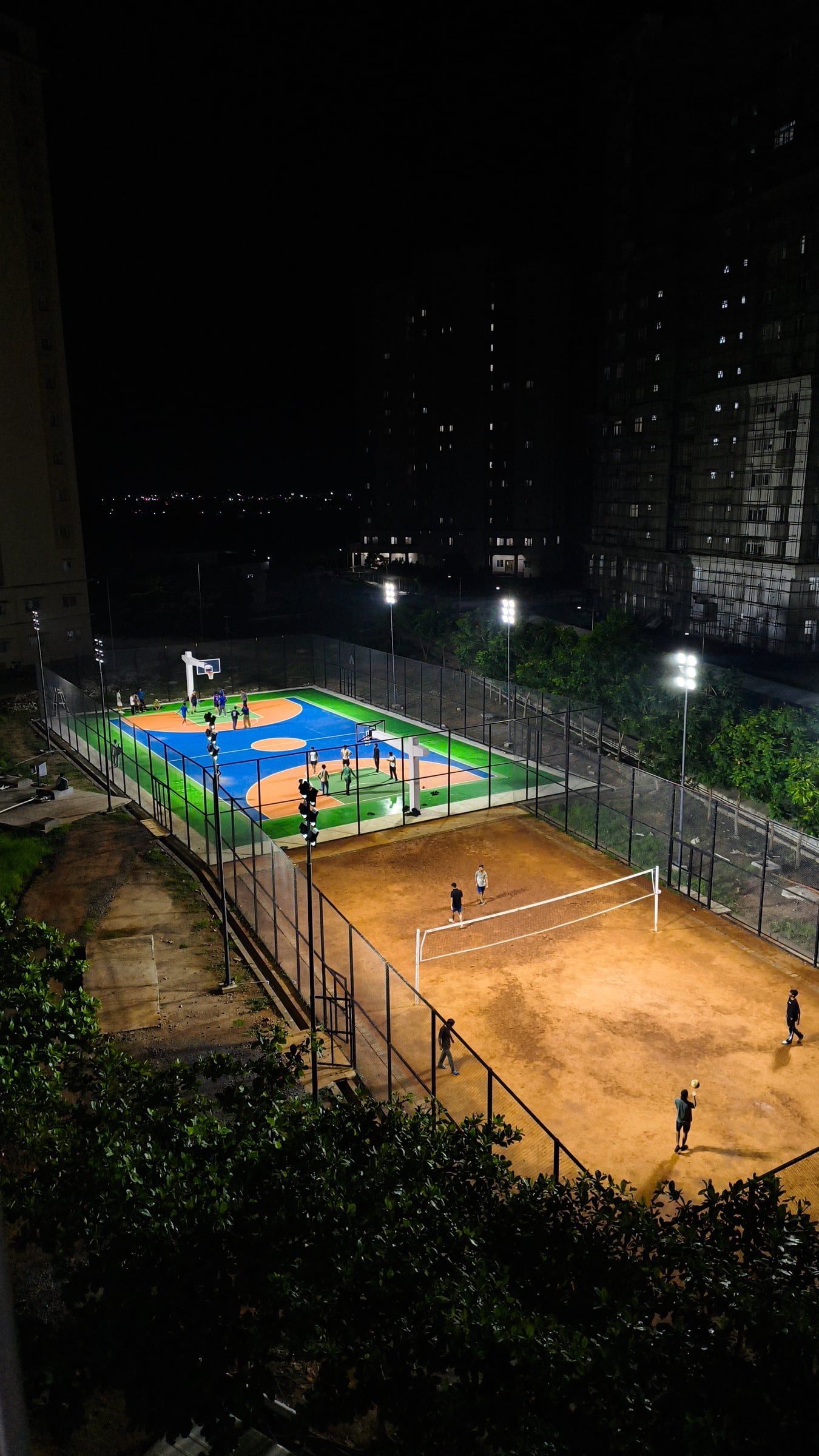 Floodlit sports courts seen from above at night