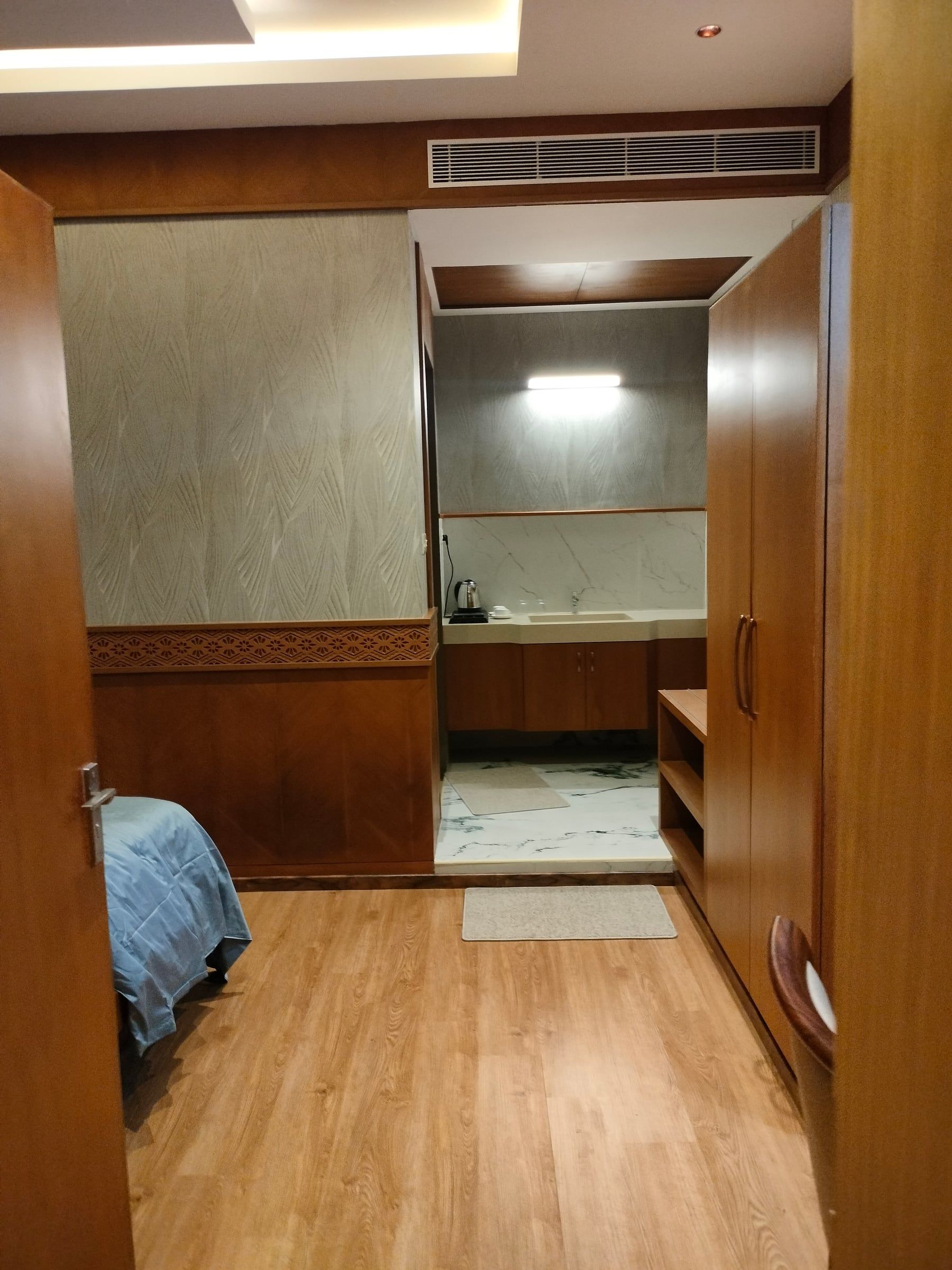 A tidy room with wooden floors and a bed